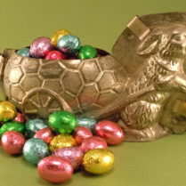 Foil wrapped chocolate eggs, pictured in an antique chocolate bunny mold