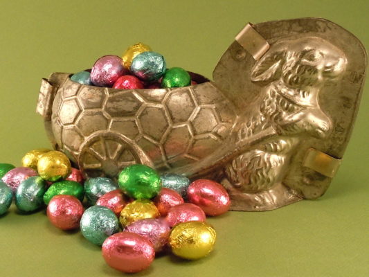 Foil wrapped chocolate eggs, pictured in an antique chocolate bunny mold