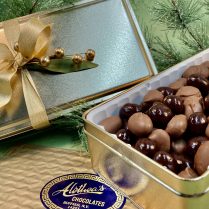 Holiday decorated gold gift tin with milk chocolate almonds and dark chocolate Montmorency cherries